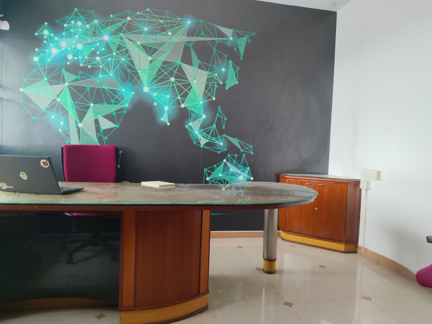 WorkMax floor — glass desk against the lit network-map wall